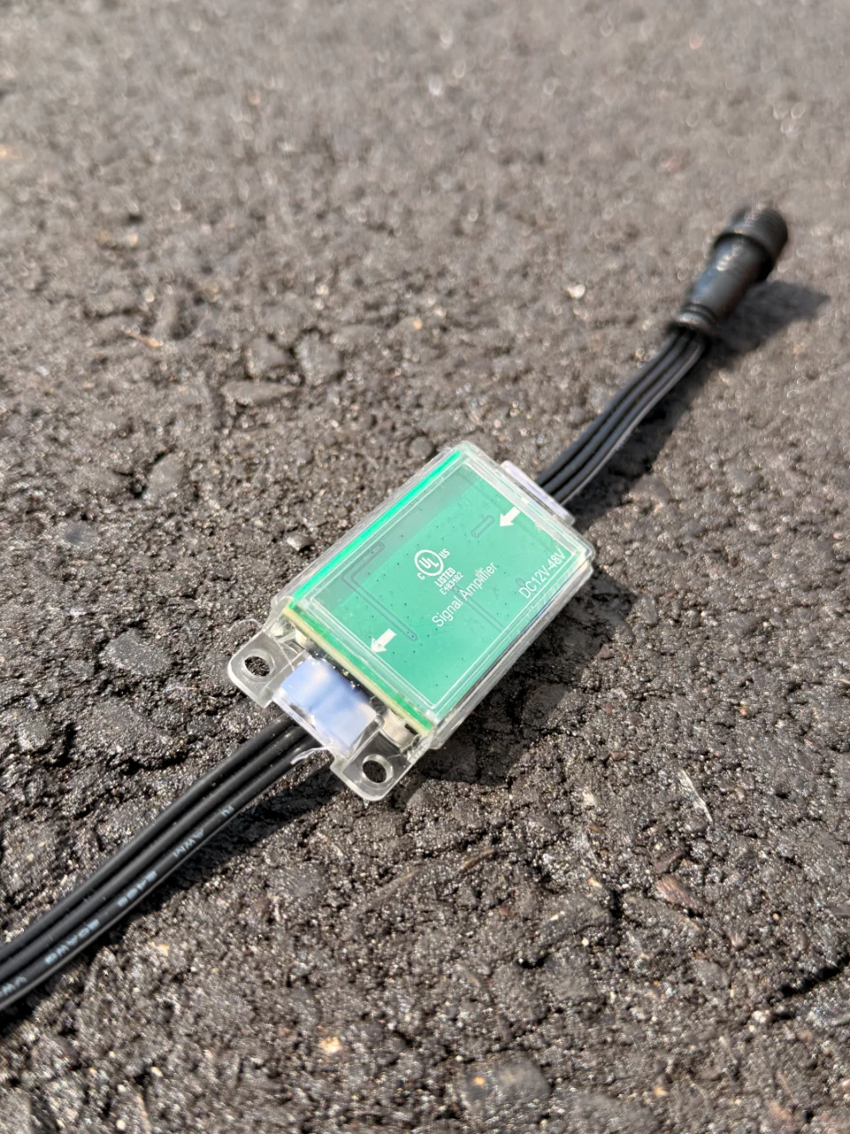 The Data Booster, a small green module wired inline on a black cable to carry the data signal further along a run