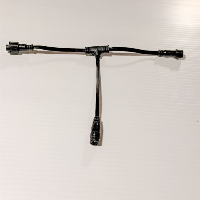 A black T connector, one lead branching into two outputs at right angles