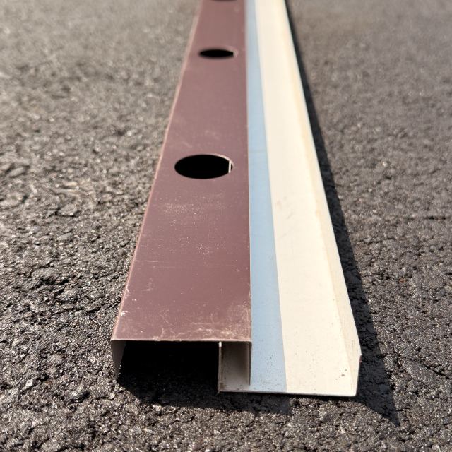 The 2-piece track with its bronze mounting base and the white front cover clipped over it