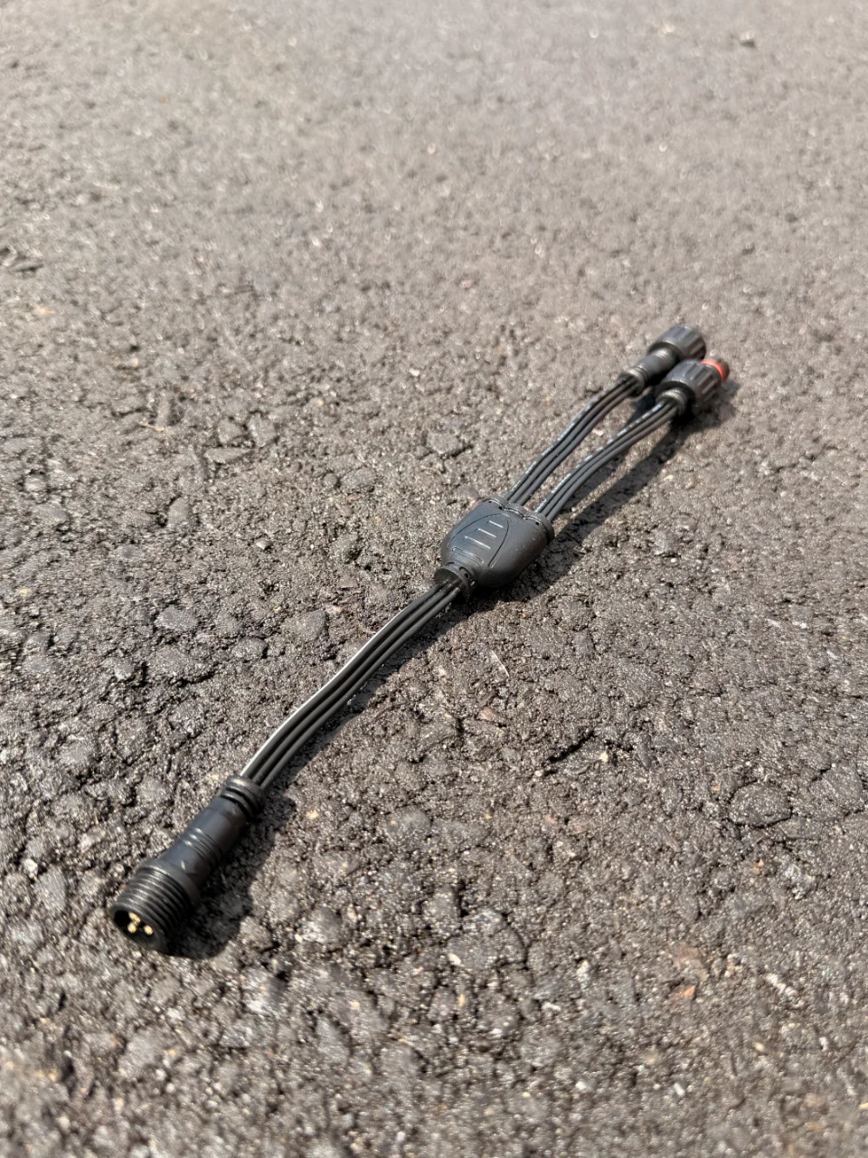A black Y connector, one input lead splitting into two outputs